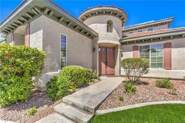 view of exterior entry with stucco siding