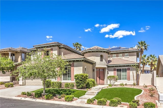 mediterranean / spanish home featuring concrete driveway, solar panels, stucco siding, an attached garage, and a tiled roof