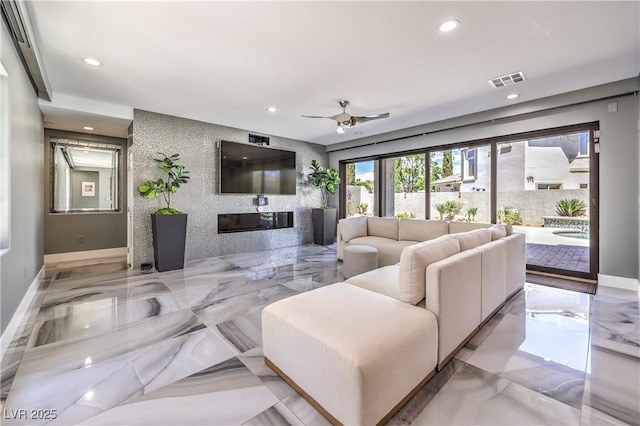 living area featuring baseboards, recessed lighting, a glass covered fireplace, and visible vents