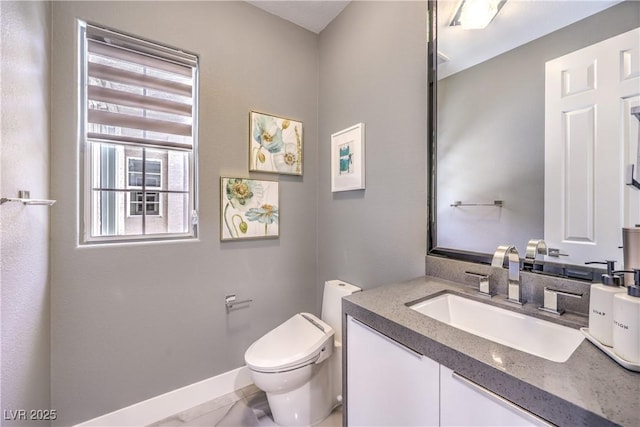 half bathroom with toilet, vanity, and baseboards