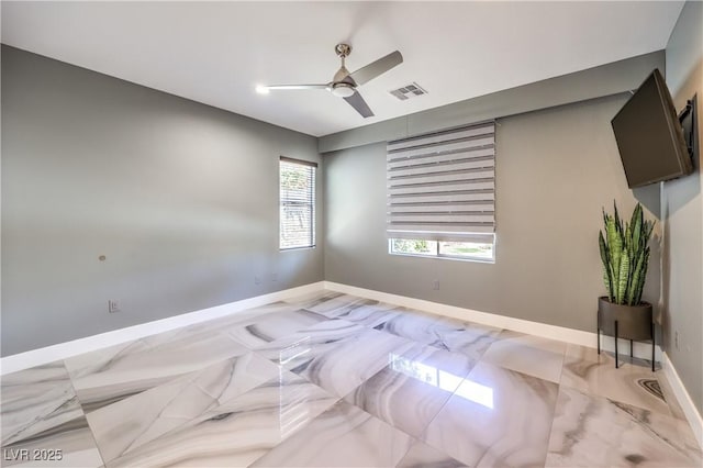 empty room with ceiling fan, baseboards, and visible vents