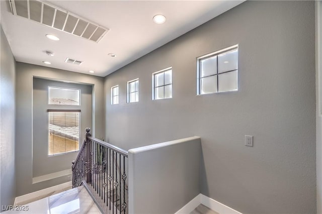 interior space with visible vents, an upstairs landing, baseboards, and recessed lighting