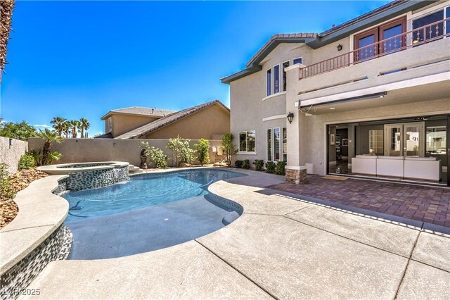 view of pool featuring a pool with connected hot tub, a patio, and a fenced backyard