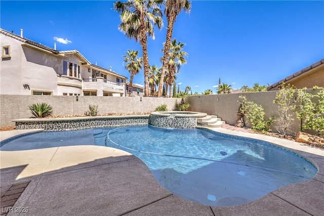 view of swimming pool with a fenced backyard and a pool with connected hot tub