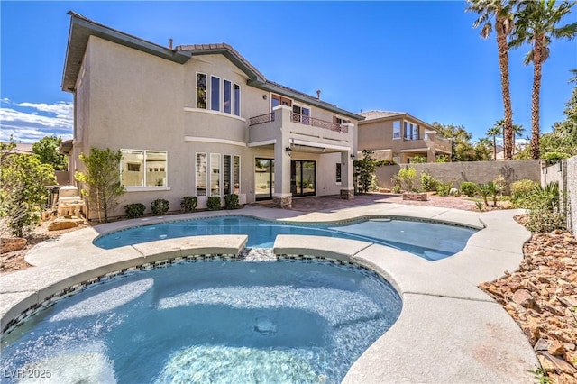view of swimming pool with a pool with connected hot tub, a patio, and a fenced backyard