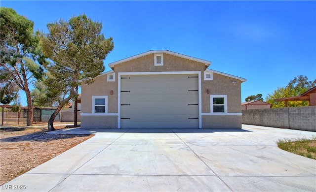 view of property exterior featuring fence, stucco siding, and driveway