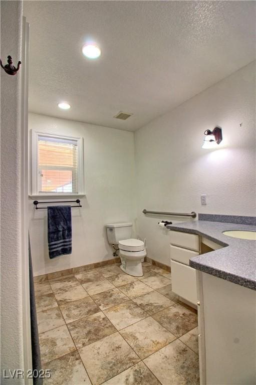 bathroom with vanity, toilet, recessed lighting, and baseboards