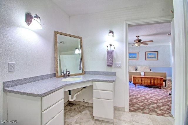 bathroom with a sink, ceiling fan, and baseboards