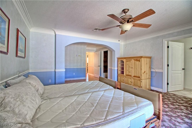 bedroom with arched walkways, crown molding, a textured ceiling, ceiling fan, and carpet flooring