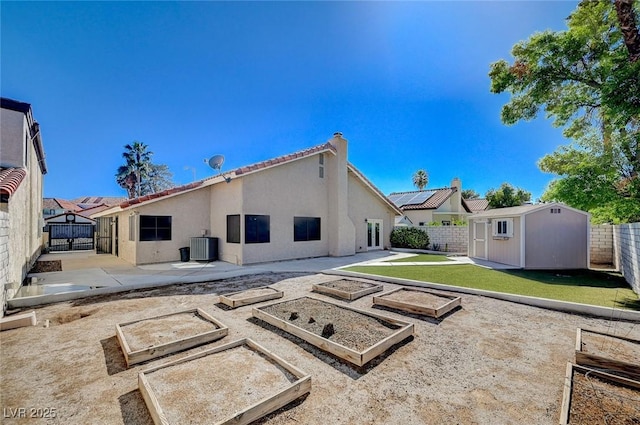 back of property with a storage unit, a fenced backyard, stucco siding, and an outdoor structure