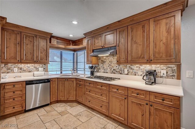 kitchen featuring appliances with stainless steel finishes, a sink, under cabinet range hood, backsplash, and recessed lighting
