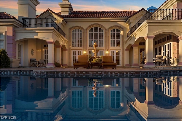 35 Ventana Canyon Dr, Las Vegas, NV 89113 - back of property at dusk with a tiled roof, a patio, an outdoor pool, and a balcony