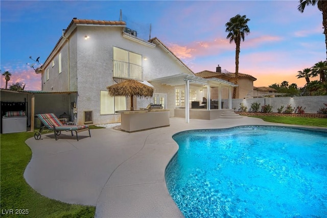 rear view of house featuring a patio, a pergola, fence, an outdoor kitchen, and a fenced in pool