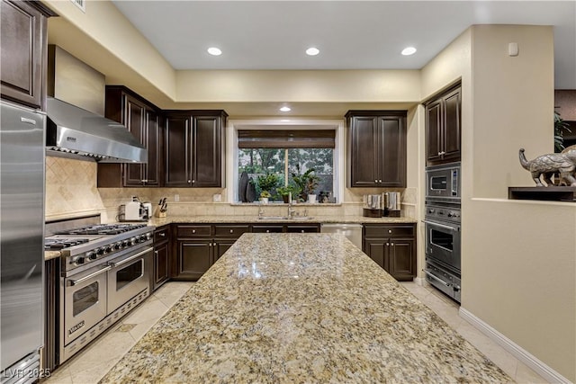 12056 Royal Dolnoch Ct, Las Vegas, NV 89141 - kitchen with built in appliances, light stone countertops, a sink, decorative backsplash, and wall chimney range hood
