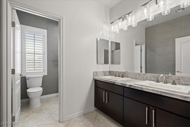 bathroom with double vanity, toilet, tile patterned flooring, and a sink