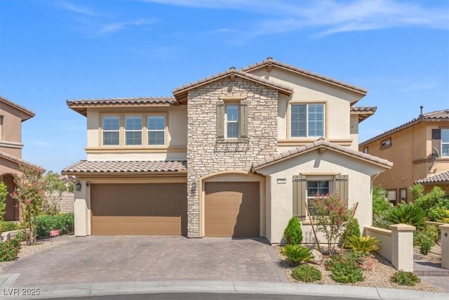 view of front facade featuring a tiled roof, stucco siding, an attached garage, and stone siding