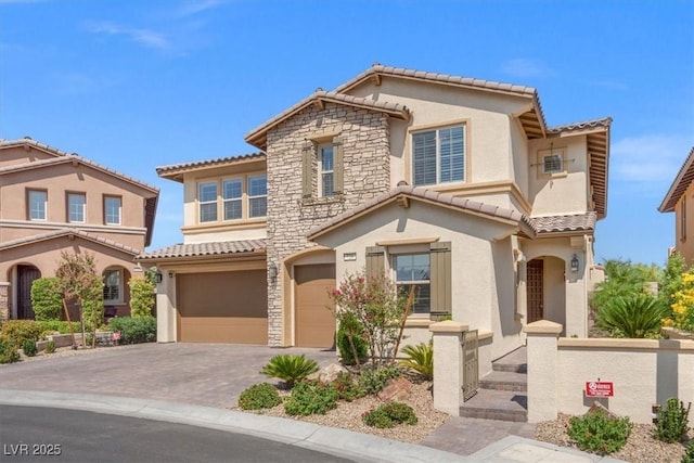 mediterranean / spanish home with a garage, a tile roof, and stucco siding
