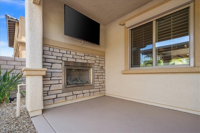 unfurnished living room featuring a textured ceiling and an outdoor stone fireplace