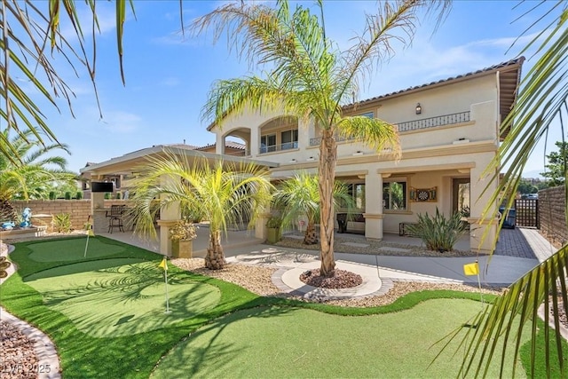 rear view of house featuring a patio area, stucco siding, and fence