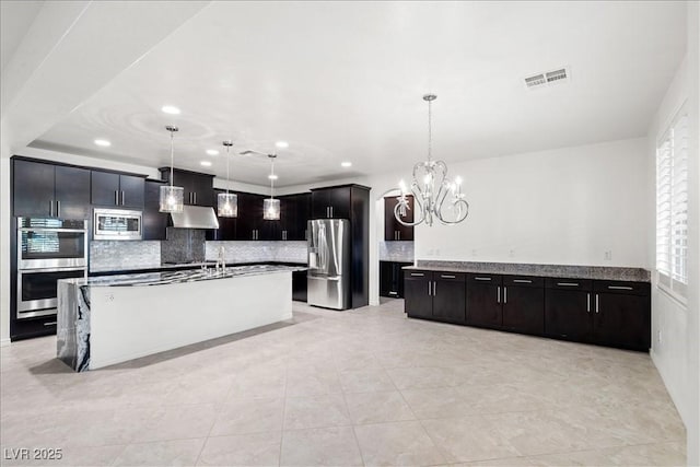 kitchen with recessed lighting, under cabinet range hood, visible vents, stainless steel appliances, and tasteful backsplash