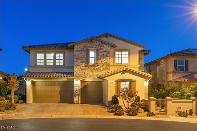 traditional-style house featuring a tiled roof, stucco siding, driveway, and a garage