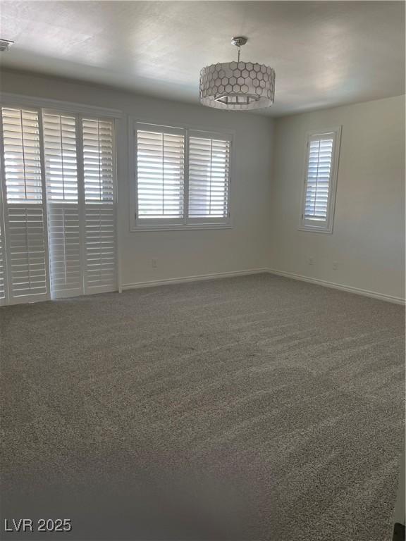 carpeted empty room featuring baseboards