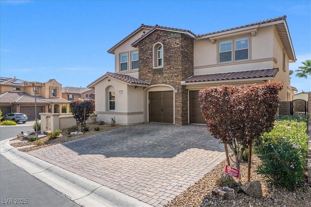 view of front facade with a tile roof, stucco siding, a garage, and decorative driveway