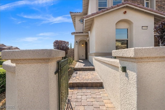 view of front of home featuring a tiled roof, stucco siding, and fence