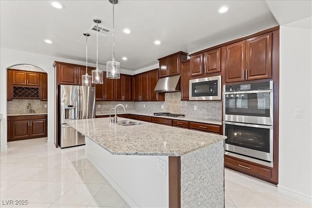 kitchen with a sink, stainless steel appliances, under cabinet range hood, and visible vents