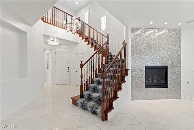 stairway featuring a large fireplace, recessed lighting, tile patterned flooring, and a notable chandelier