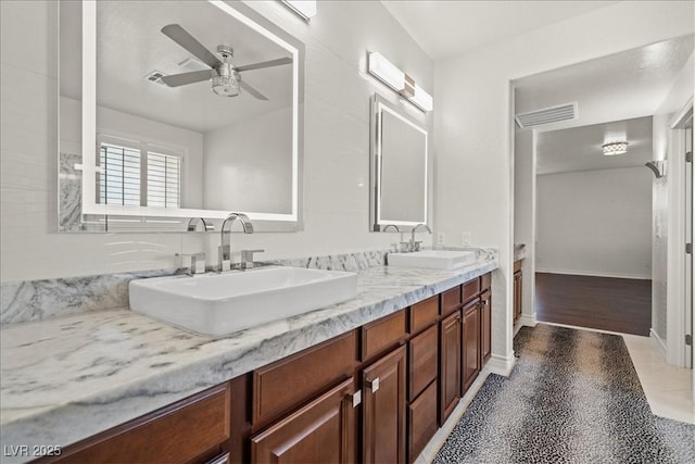 full bathroom with a sink, double vanity, a ceiling fan, and visible vents