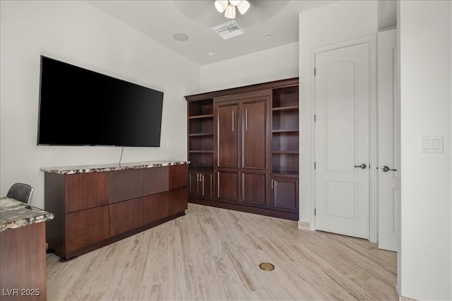 unfurnished living room with light wood-type flooring, visible vents, and a ceiling fan