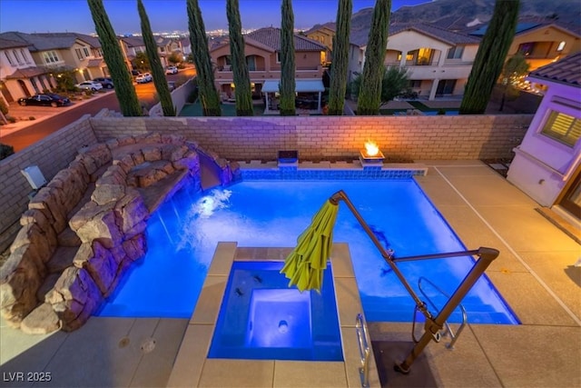 view of pool featuring an in ground hot tub, a residential view, and a fenced in pool