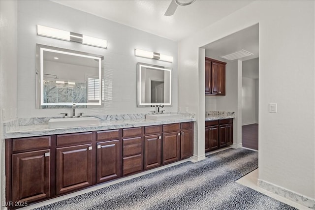 bathroom with a ceiling fan, baseboards, double vanity, and a sink