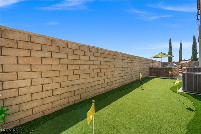 view of yard featuring central AC unit and a fenced backyard
