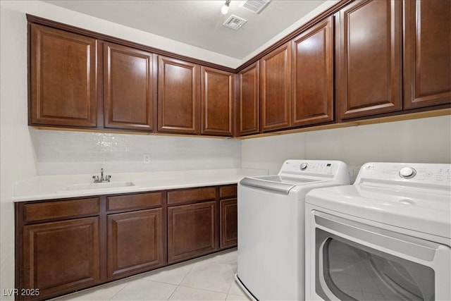 laundry room with a sink, washer and clothes dryer, cabinet space, and visible vents