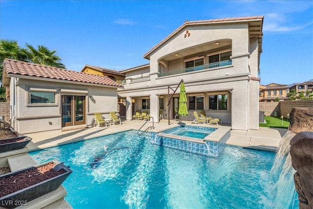 rear view of property with stucco siding, a patio, fence, and a balcony