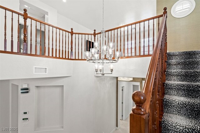 stairs featuring tile patterned flooring, an inviting chandelier, visible vents, and high vaulted ceiling