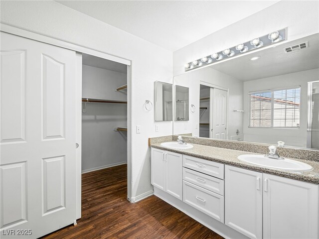 1153 Stormy Valley Rd, Las Vegas, NV 89123 - bathroom with wood finished floors, double vanity, a spacious closet, and baseboards