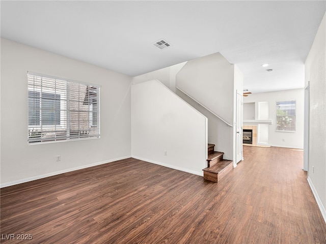 1153 Stormy Valley Rd, Las Vegas, NV 89123 - unfurnished living room with wood finished floors, stairway, baseboards, a tile fireplace, and recessed lighting