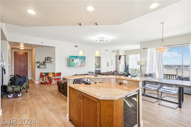 8255 Las Vegas Blvd Unit 713, Las Vegas, NV 89123 - kitchen with brown cabinetry, wine cooler, pendant lighting, light wood finished floors, and open floor plan