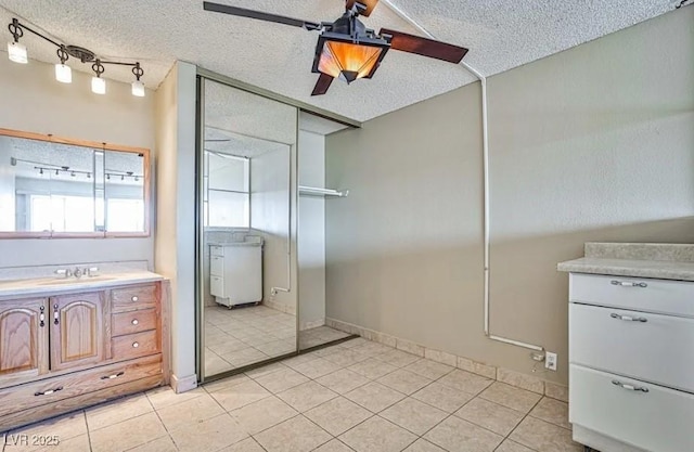 bathroom with tile patterned flooring, a textured ceiling, and vanity