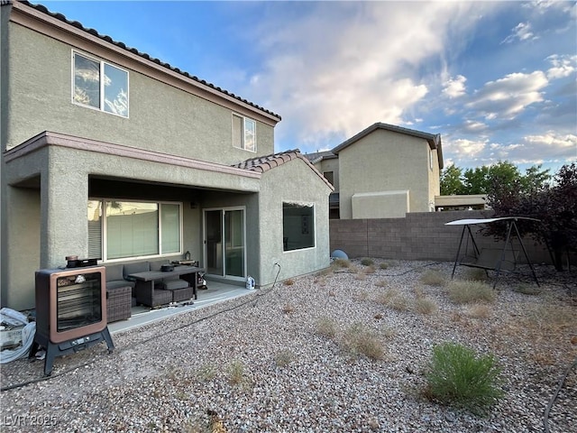 rear view of property with a tile roof, a patio, stucco siding, a fenced backyard, and outdoor lounge area