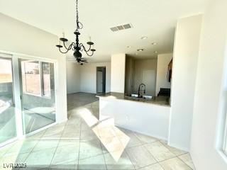 interior space with light tile patterned flooring, a notable chandelier, and visible vents