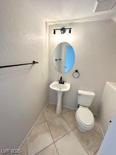 bathroom featuring toilet, visible vents, and tile patterned floors