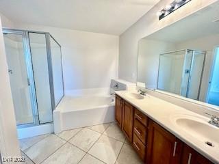 full bath featuring a sink, double vanity, a garden tub, and a shower stall