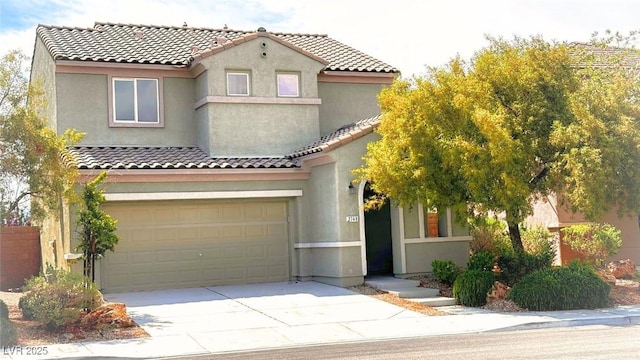 mediterranean / spanish home with concrete driveway, stucco siding, a tiled roof, and an attached garage