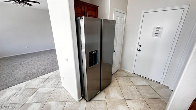 kitchen with a ceiling fan, light carpet, stainless steel fridge, and light tile patterned flooring