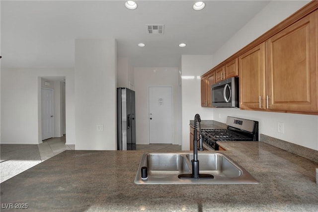 2749 Invermark St, Henderson, NV 89044 - kitchen with stainless steel appliances, dark countertops, recessed lighting, and brown cabinets
