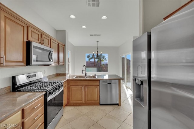 2749 Invermark St, Henderson, NV 89044 - kitchen with stainless steel appliances, a peninsula, a chandelier, light tile patterned floors, and recessed lighting